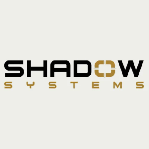The image shows the logo for "Shadow Systems." The word "SHADOW" is in bold black text, with the "O" designed like a gold crosshair. Below, "SYSTEMS" appears in smaller gold capital letters.